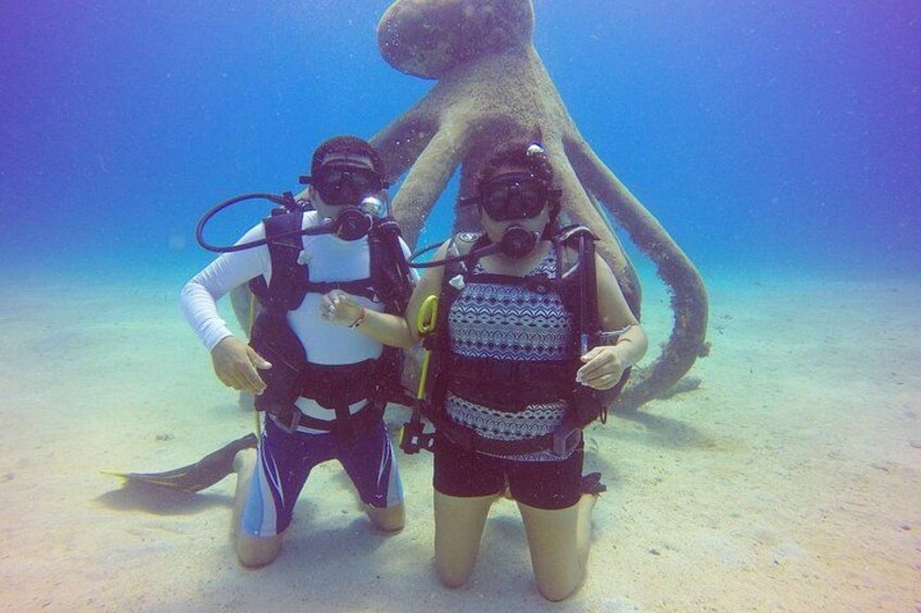 Two scuba divers with a large octopus in the background. 5