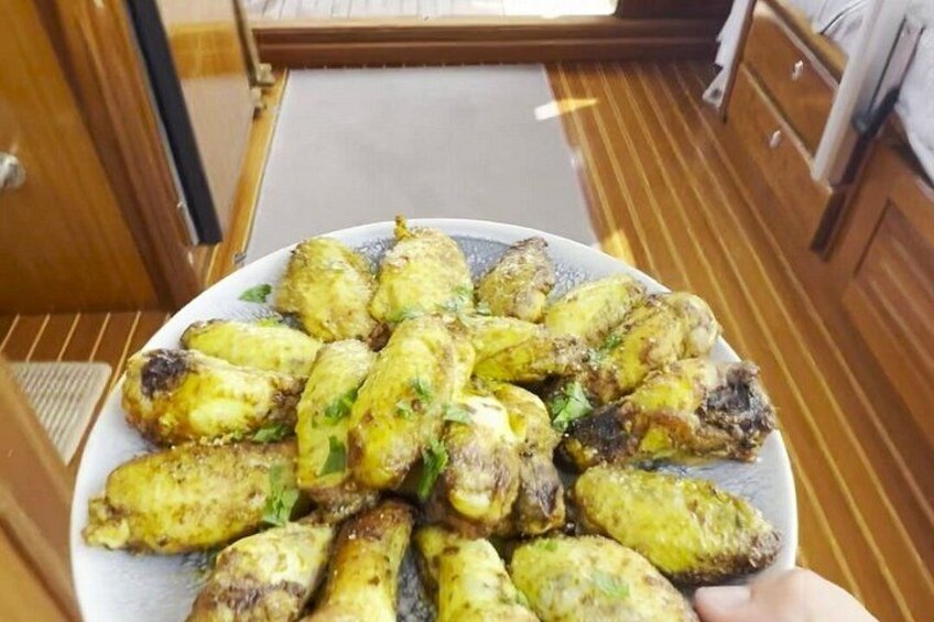 A plate of grilled chicken wings garnished with herbs. 4
