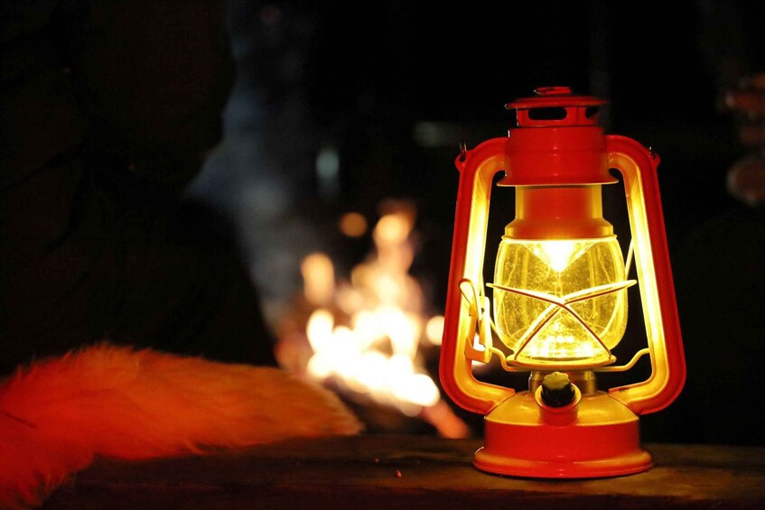 A red lantern with a glowing light, placed near a fire. 4