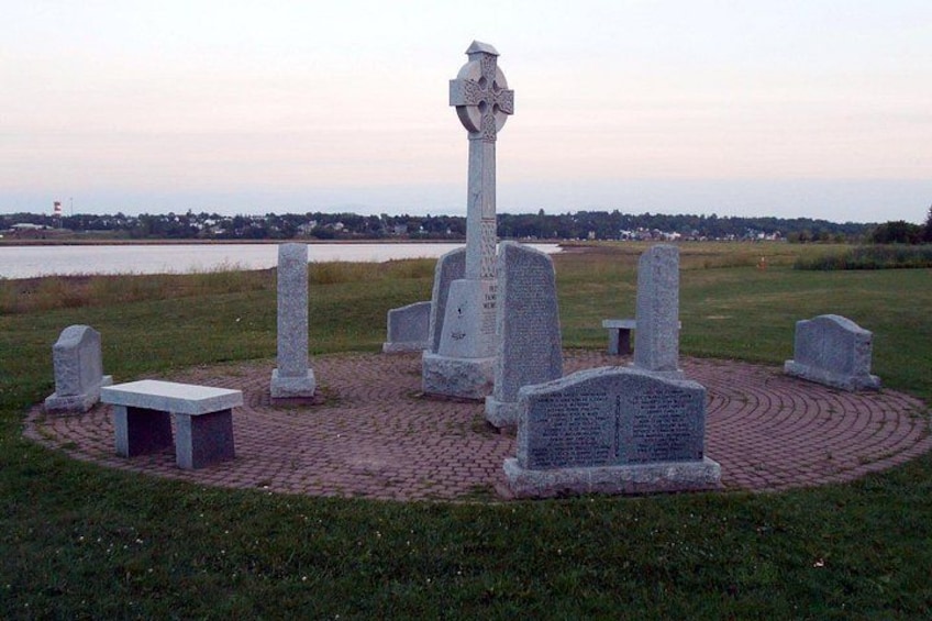 A cemetery with a central cross monument surrounded by gravestones. 5