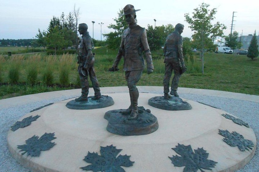 A circular monument with three bronze statues of soldiers. 1