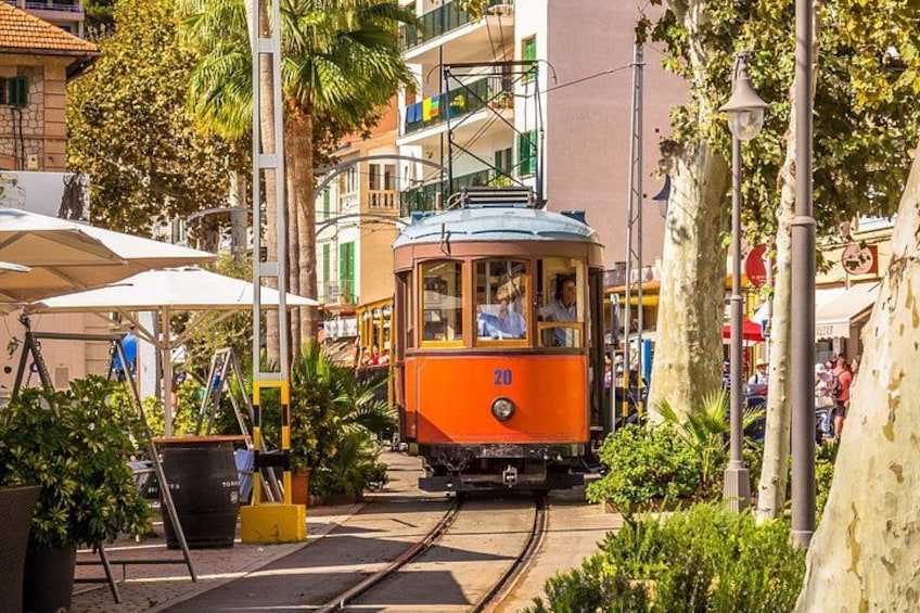 Un tramway circule sur les rails, entouré de verdure et de bâtiments. 3
