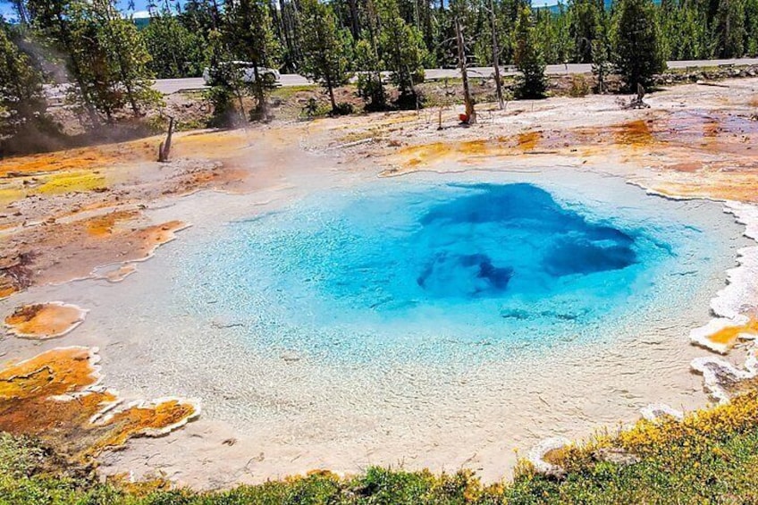 Una fuente termal geotérmica con un centro azul rodeado de depósitos minerales. 3