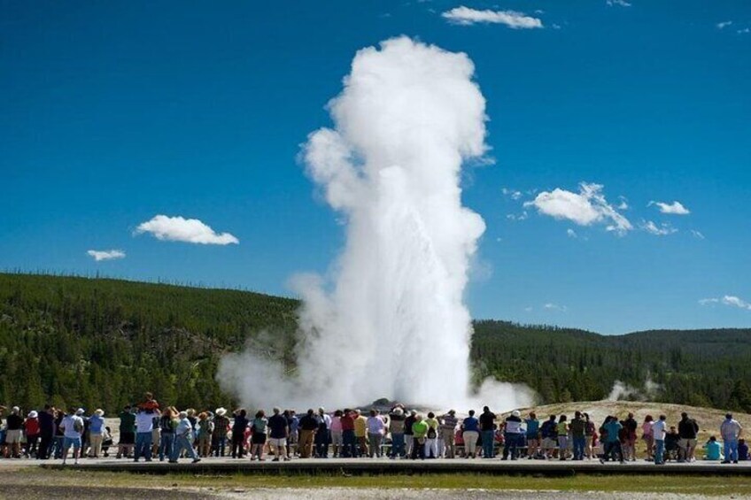 Un géiser en erupción, con una multitud de personas observando. 1