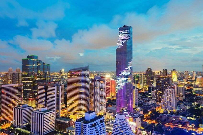Une vue sur une ville au crépuscule, avec des gratte-ciel illuminés et un ciel dégagé. 4