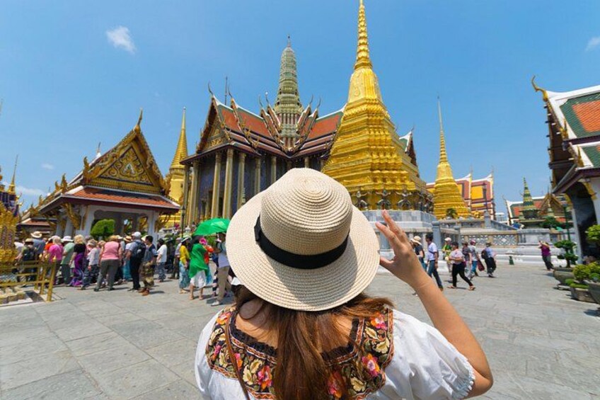 Un touriste devant un ensemble de temples caractérisé par ses flèches dorées et son architecture traditionnelle. 1