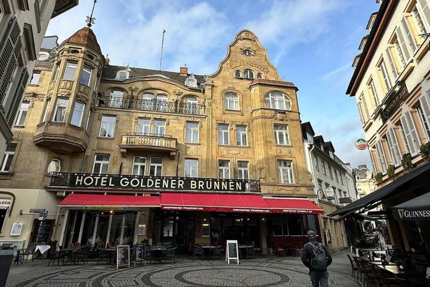 A historic building with a sign for Hotel Goldener Brunnen. 5