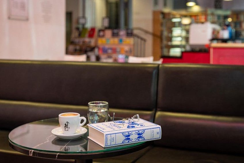 A table with a cup of coffee, a glass of water, and a board game in a cafe. 4