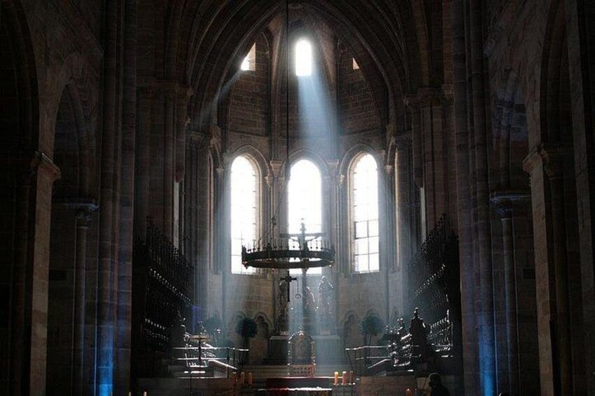 L’intérieur d’une cathédrale, avec de hautes fenêtres en arc, un autel central et un lustre. 4