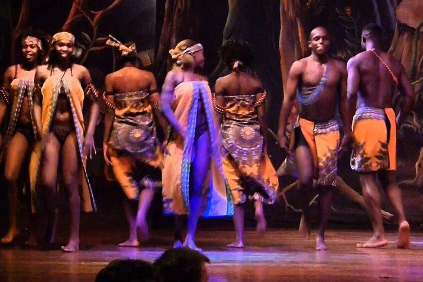 A group of people in traditional costumes performing on a stage. 2