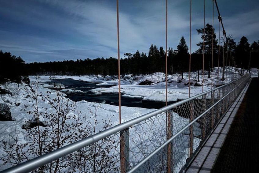 Et sneklædt landskab med en bro og en flod. 3