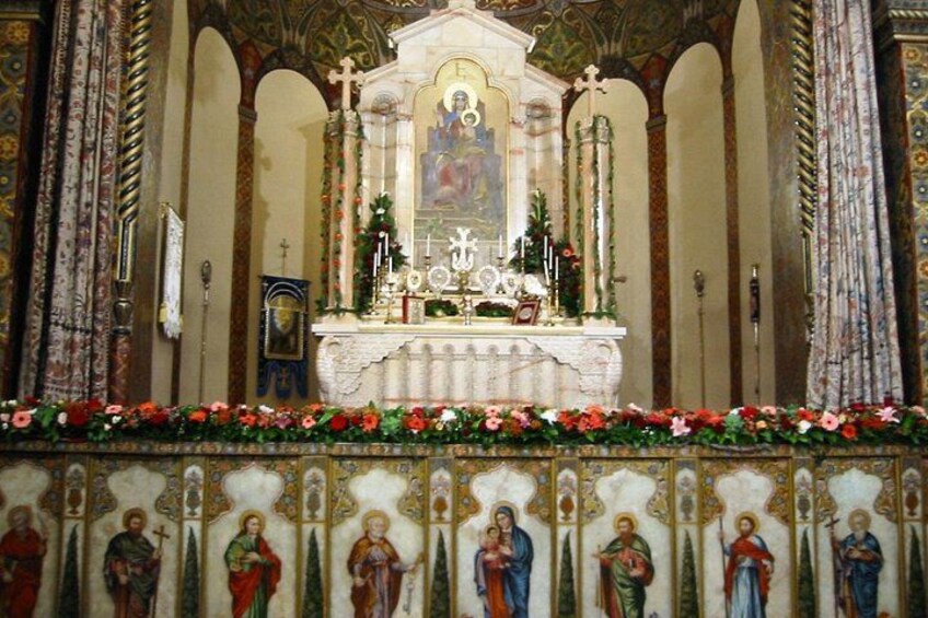 Interno di una chiesa decorata con un altare centrale, dipinti religiosi e ornamenti floreali. 5