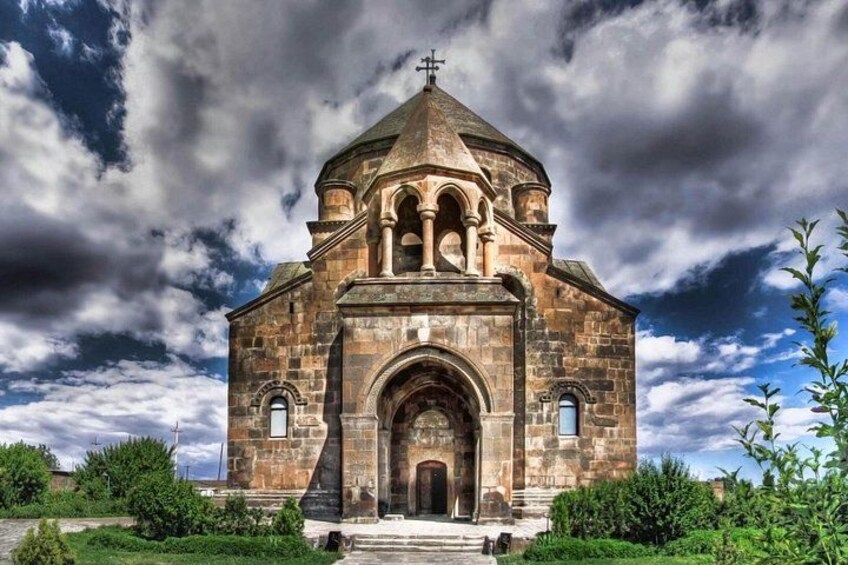 Una chiesa storica in pietra con una cupola centrale, finestre ad arco e una croce sulla sommità. 2