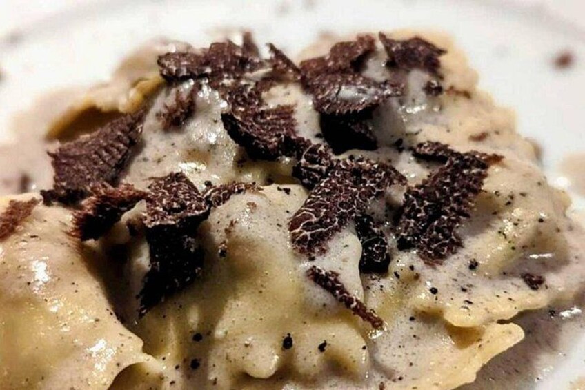 Tæt på ravioli med cremet sauce og mørke chokoladespåner ovenpå. 2