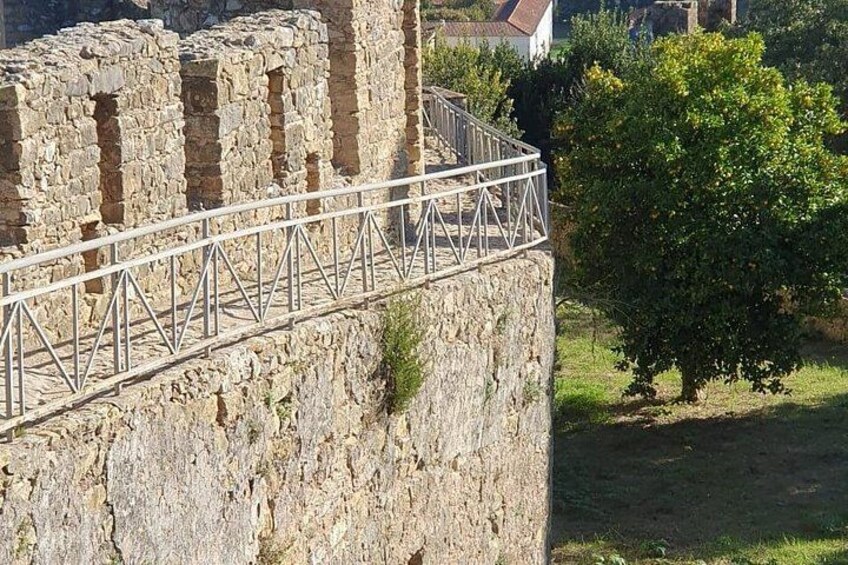 A stone wall with a metal railing. 1