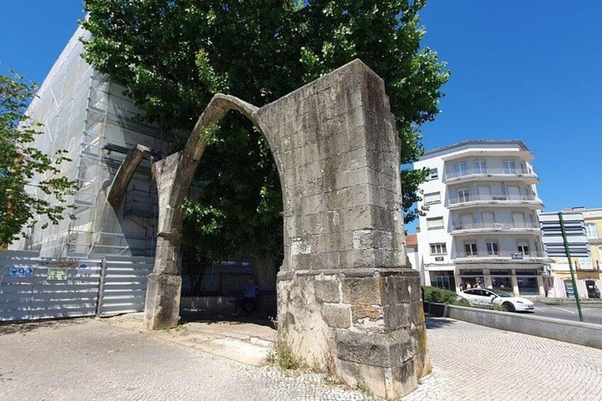 A stone archway, a modern building, and a multi-story residential building. 2