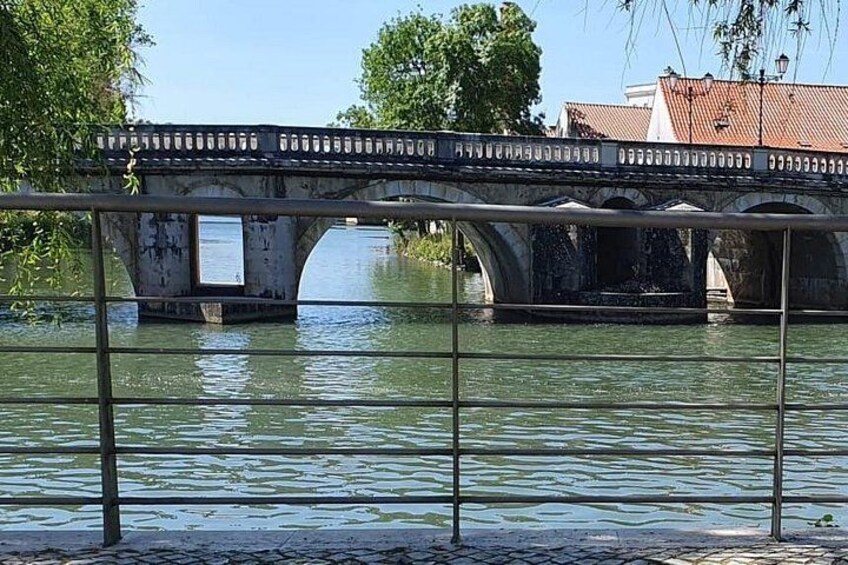 A bridge over water with a metal railing in the foreground. 5