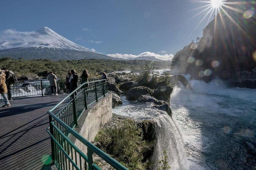 A waterfall, a bridge, and a snow-capped mountain in the background. 2