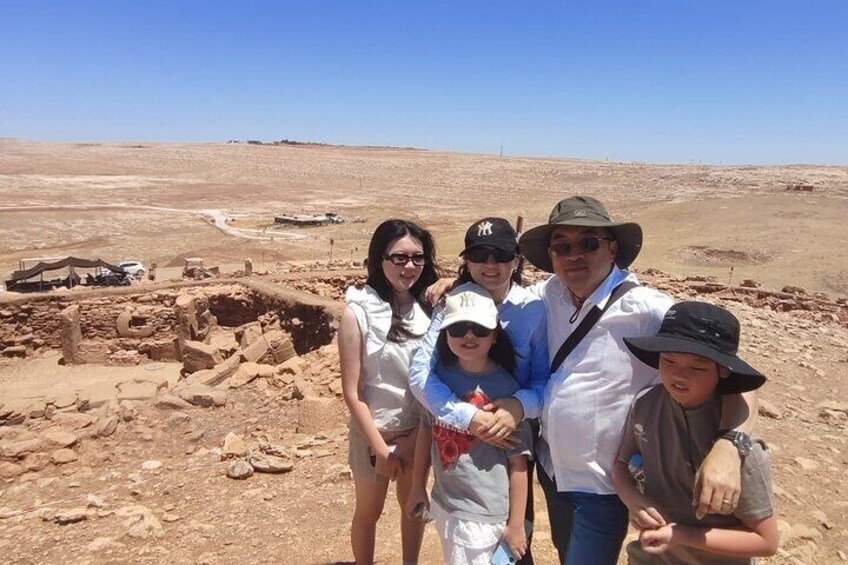 A family at an archaeological site with ancient ruins in the background. 3