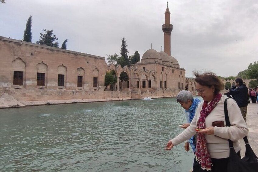 A historic building with a minaret and a body of water in the foreground. 4