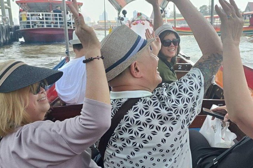 Des personnes se trouvent sur un bateau, les bras levés, peut-être pour prendre une photo ou pour célébrer quelque chose. 1