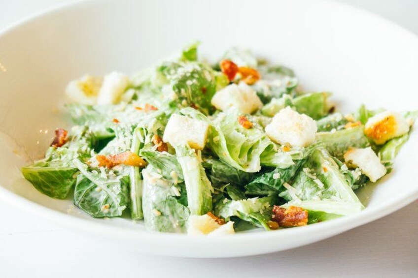 Une salade César composée de laitue, de croûtons et de fromage. 4