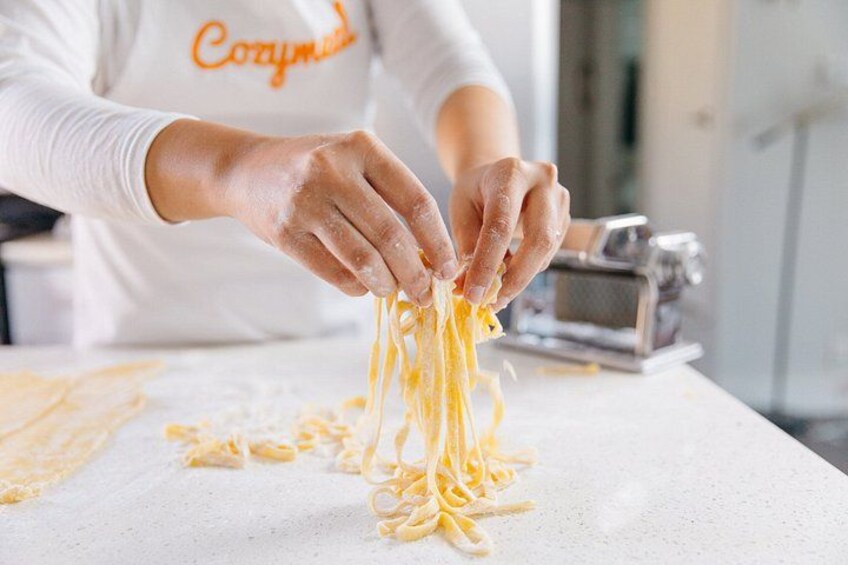 Una persona preparando pasta en la encimera de una cocina. 1