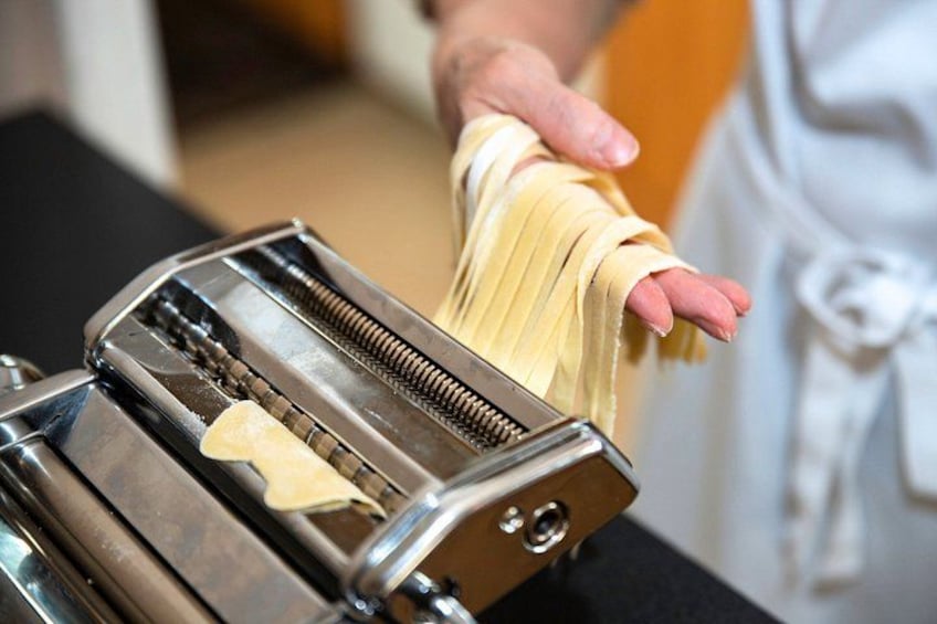 Una persona usando una máquina para hacer pasta. 3