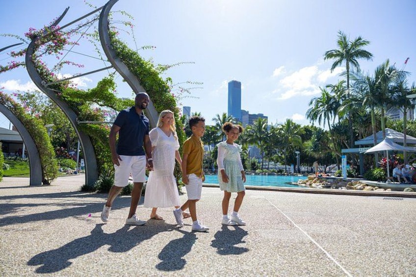 A family walking on a paved area with a pool and palm trees in the background. 3