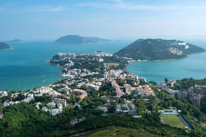 Un paysage urbain côtier caractérisé par une forte densité de constructions, une vaste étendue d’eau et une colline imposante parsemée de bâtiments. 2