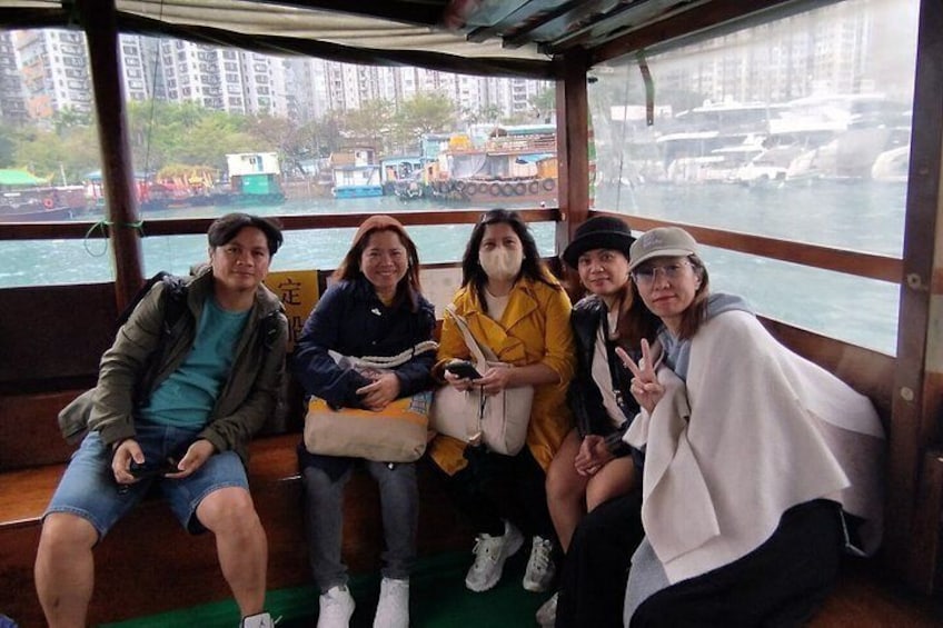 Un groupe de personnes se trouve sur un bateau, avec une vue sur la ville en arrière-plan. 4