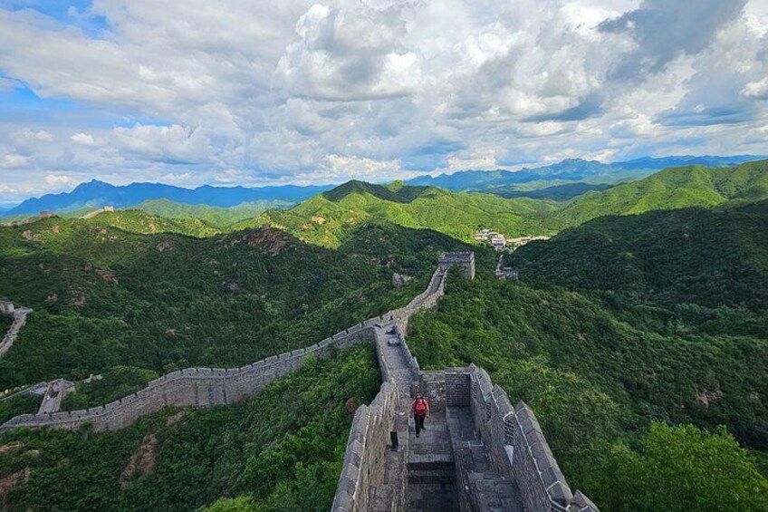 The Great Wall of China winding through lush green hills. 4