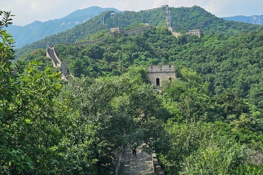 De Chinese Muur, een weelderig groen bos en een klein stenen gebouw. 4