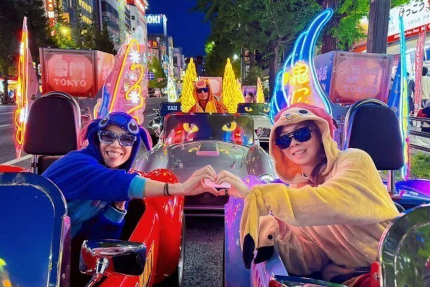 A brightly lit street with neon signs and a vehicle decorated with colorful lights and patterns. 1