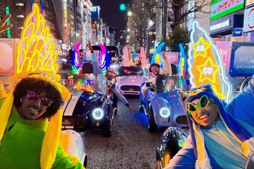 A parade with people in colorful costumes and vehicles decorated with neon lights. 5
