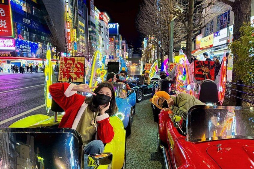 A nighttime street scene with colorful, illuminated vehicles and neon signs. 4