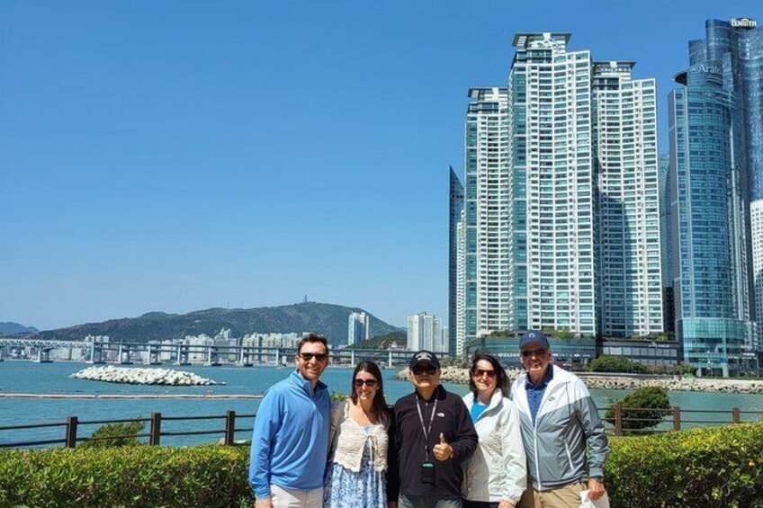 Un grupo de personas frente a un paisaje urbano con edificios altos y una masa de agua. 5