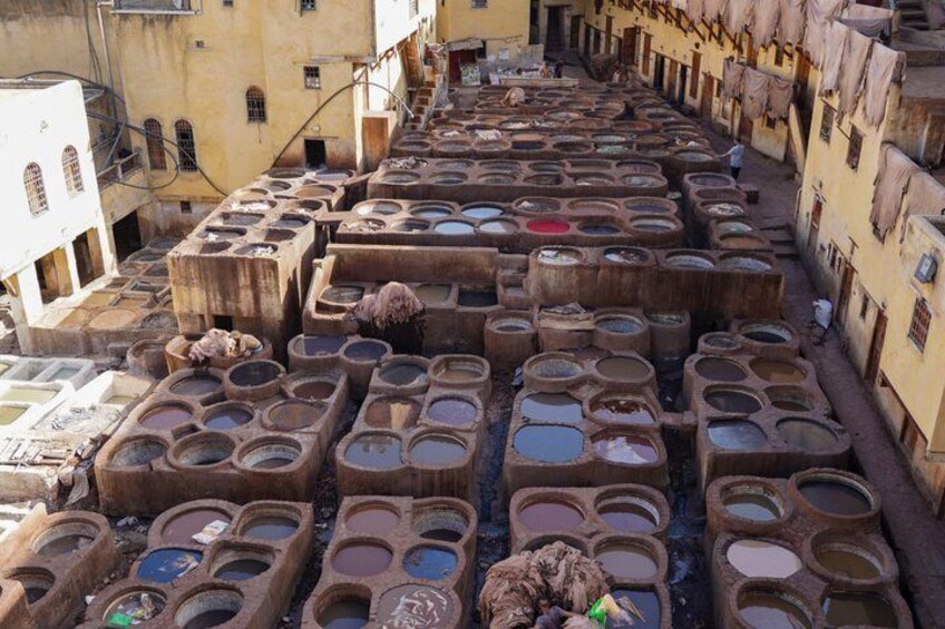 A row of large, empty, stone basins in a narrow alleyway. 4
