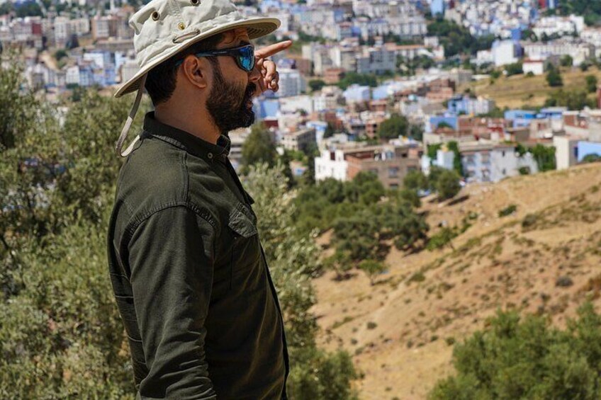 A person standing on a hill overlooking a densely packed urban area with buildings. 2