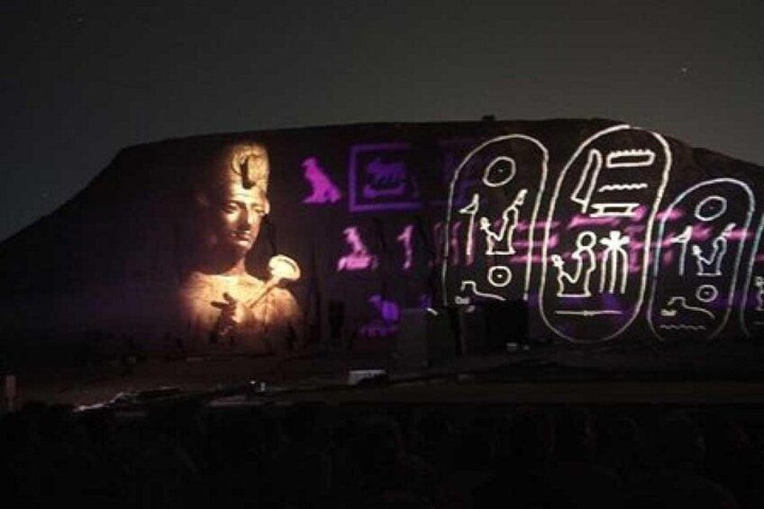 Eine große, beleuchtete Struktur mit einer zentralen Figur und umliegenden Symbolen. 2