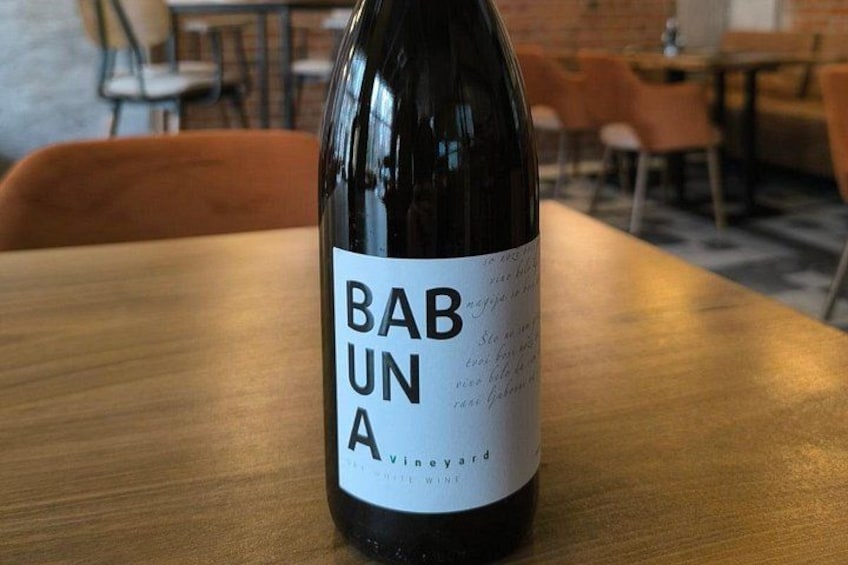 A bottle of Babuna wine on a wooden table in a cafe. 2