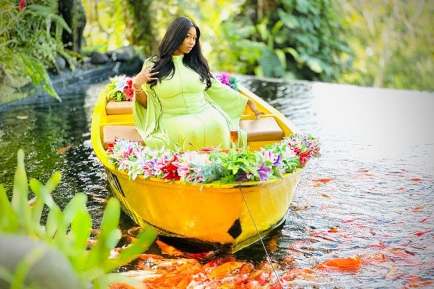 A woman in a yellow boat with flowers, surrounded by greenery. 4