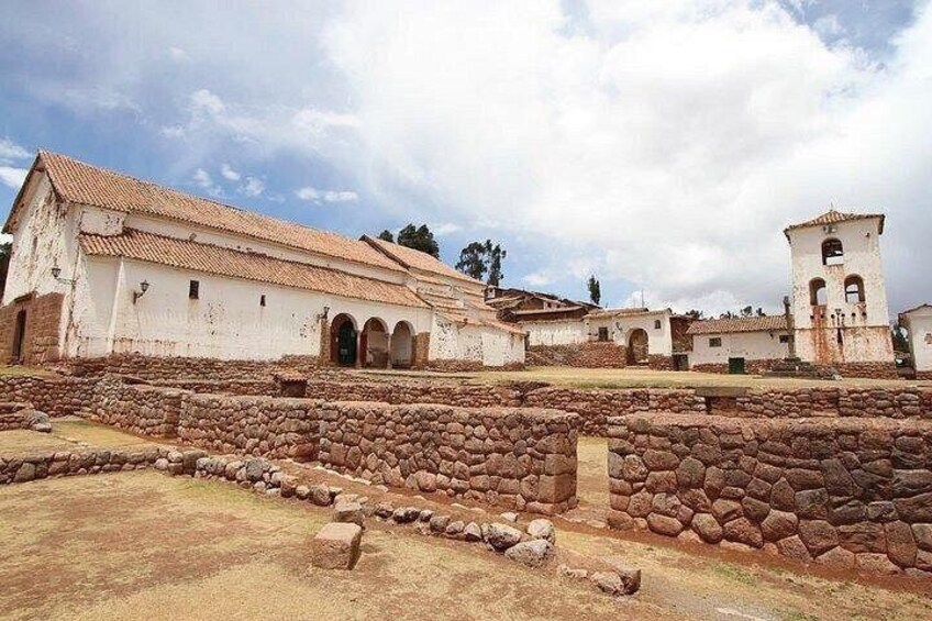 An ancient stone wall, a white building with a red roof, and a bell tower. 2