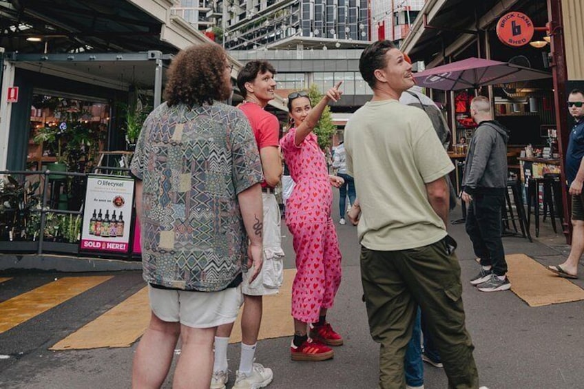 People standing on a street with shops and a signboard. 3