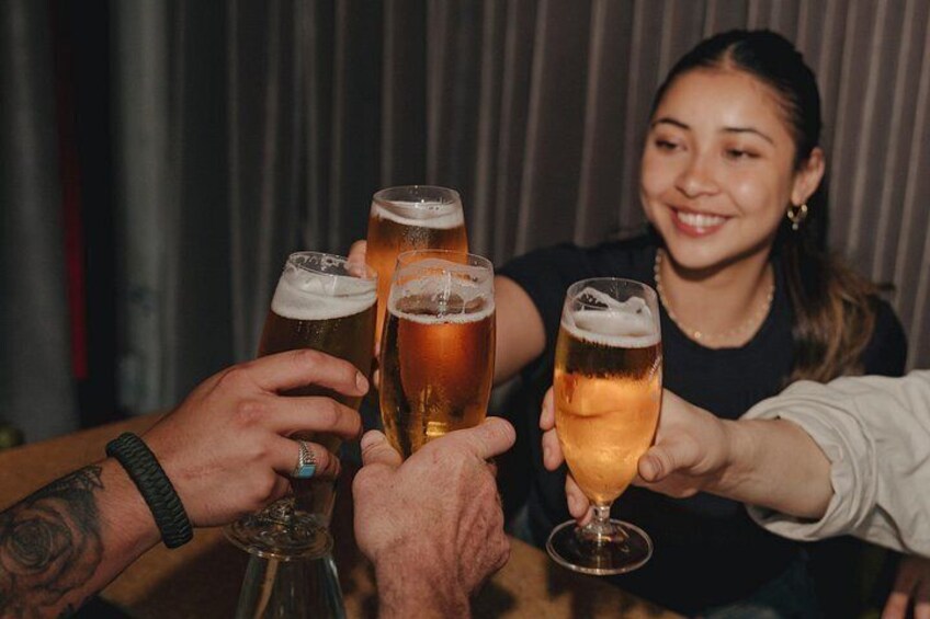 A group of people toasting with beer glasses. 2