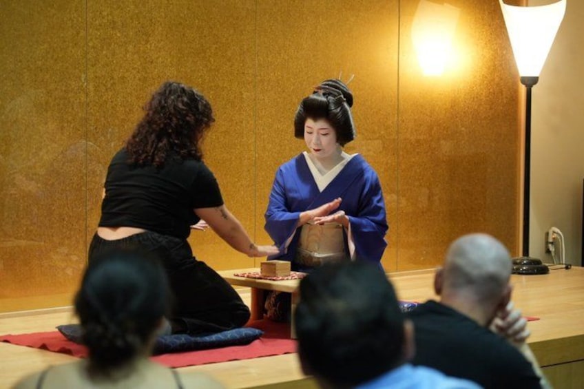 Une cérémonie du thé japonaise traditionnelle, avec une femme vêtue de noir et un homme vêtu de bleu, qui exécutent le rituel. 5