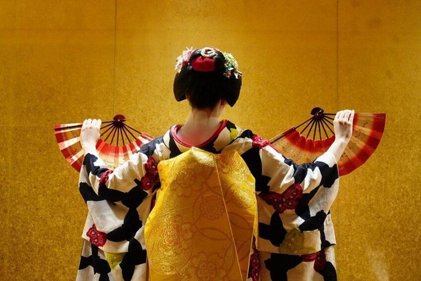 Una persona vestida con traje tradicional japonés y un abanico. 1