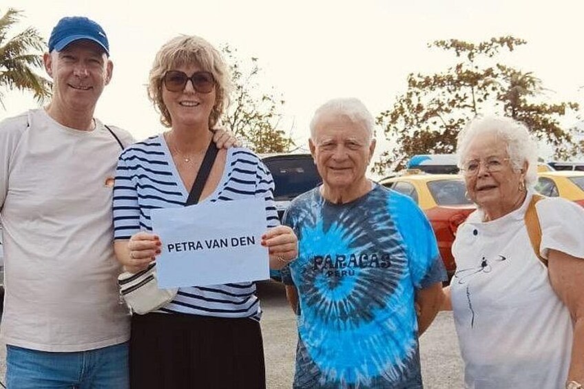 Four people standing outdoors, holding a sign that reads 'PETRA VAN DEN.' 5