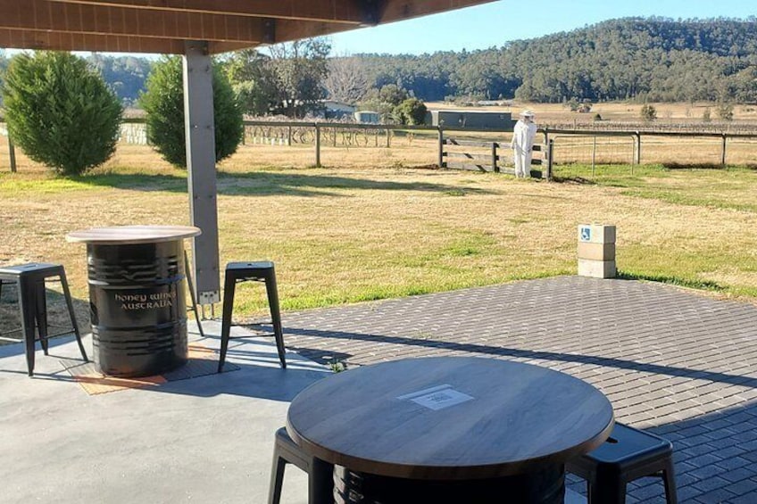 An outdoor patio with a round table and chairs, a trash can, and a wooden post with a sign. 3