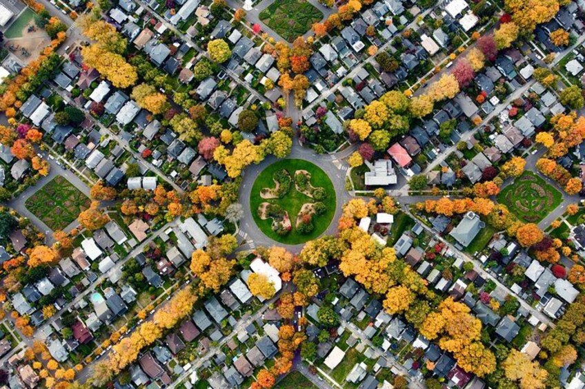 An aerial view of a residential area with houses, trees, and a central park. 4